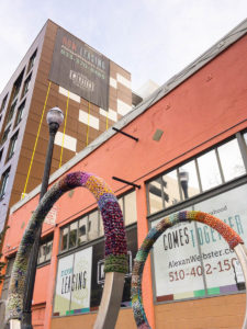 Image of two yarn-bombed bike racks outside of the new Alexan Webster apartment building